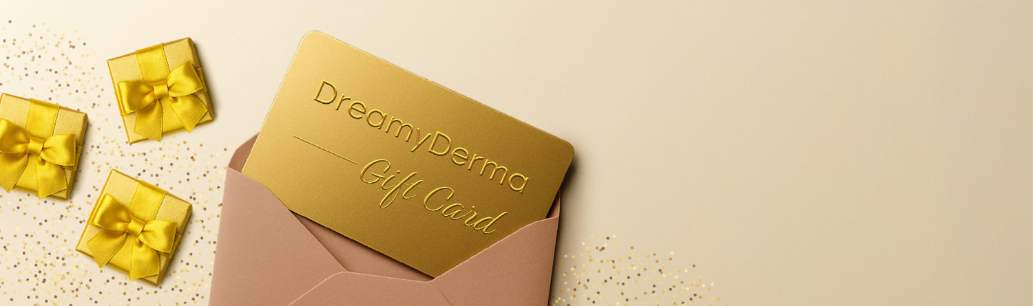 Gold gift card with 'DreamyDerma' branding on a beige envelope with yellow gift boxes.