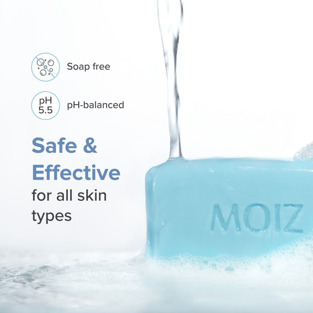 MOIZ syndet bathing bar with water being poured over it, labeled as soap-free and pH-balanced for all skin types.